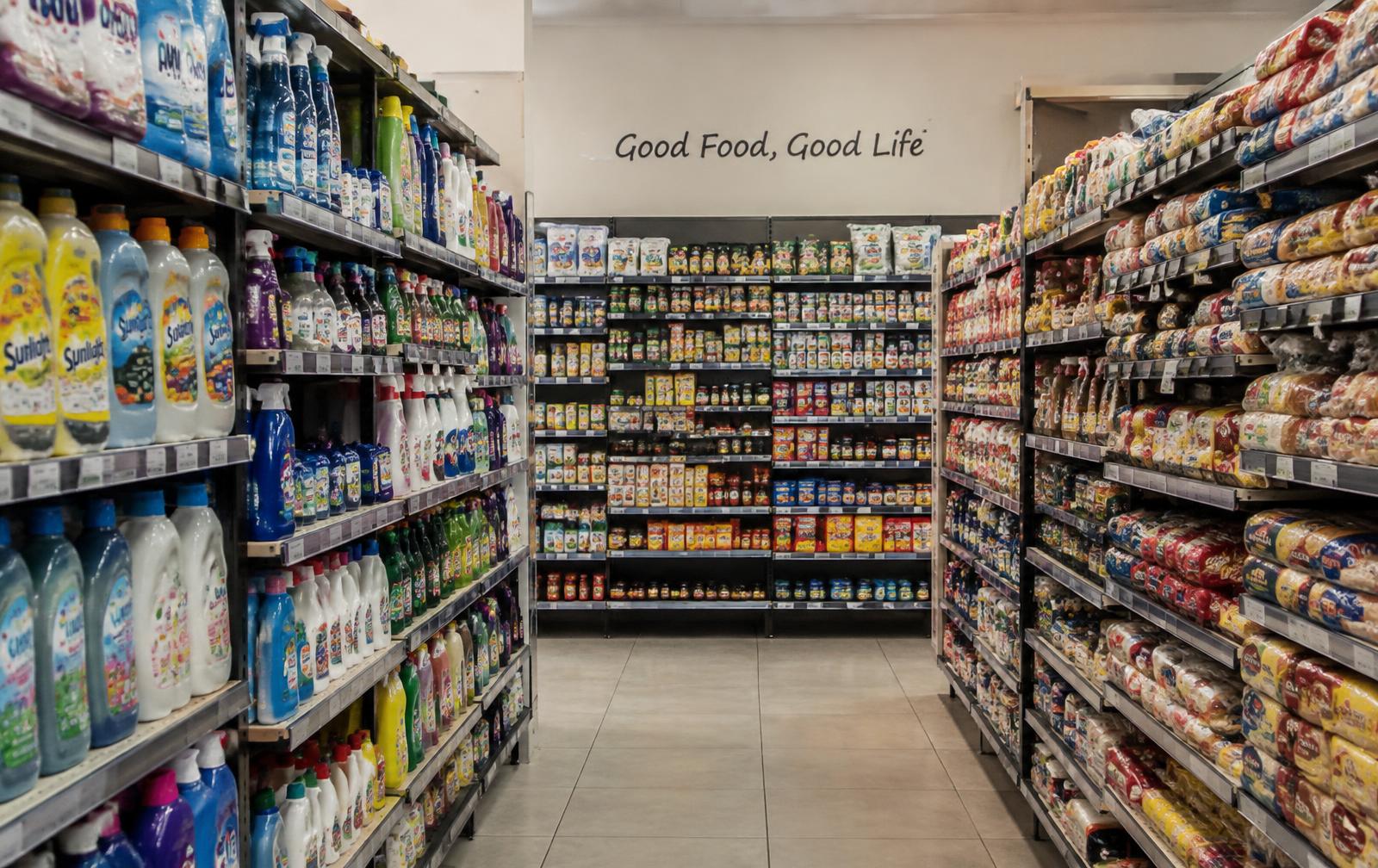 Stocked shelves of food and cleaning products in a retail store aisle